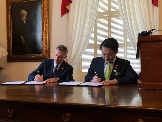 姉妹提携記念式典で協定書に署名する平井知事とフィル・スコットバーモント州知事