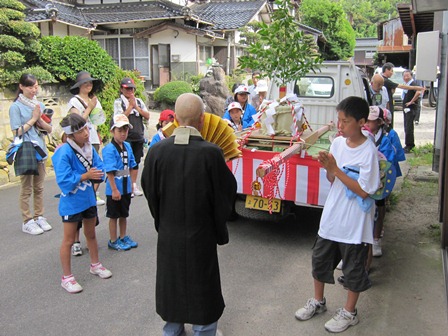 大谷地区自治公民館前での僧侶による式典の様子の写真